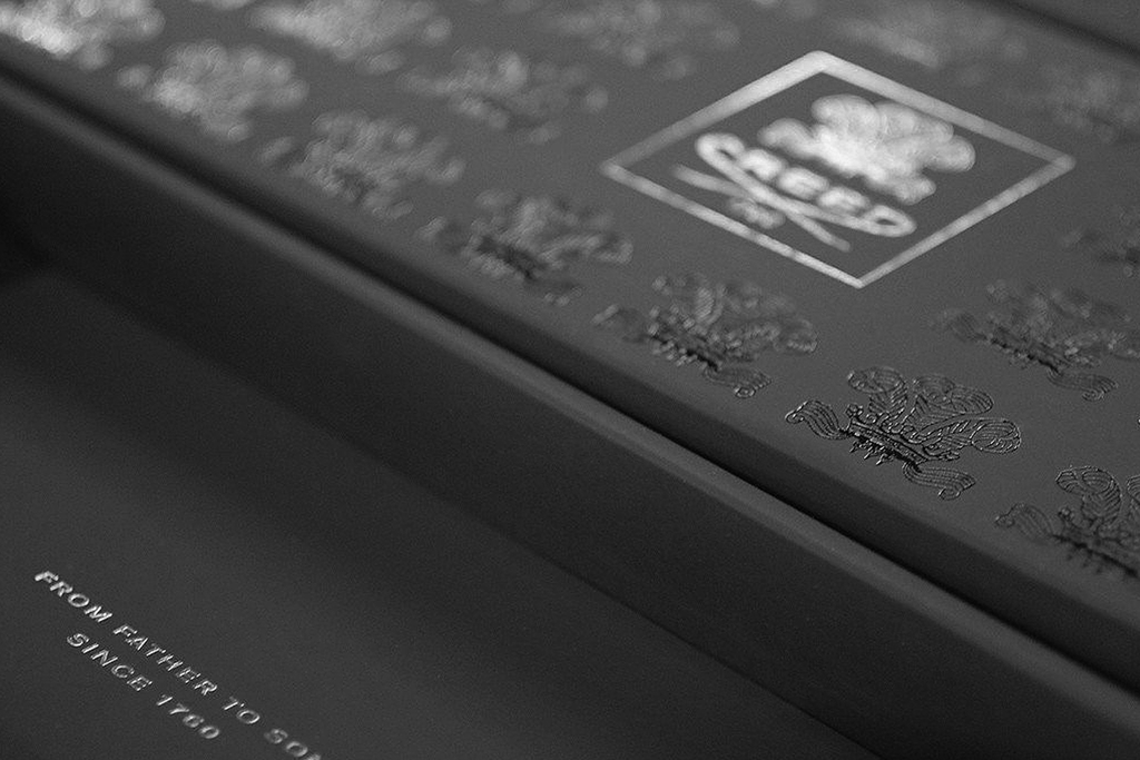 Close up of a black box with spot gloss printing and silver hot foil stamping